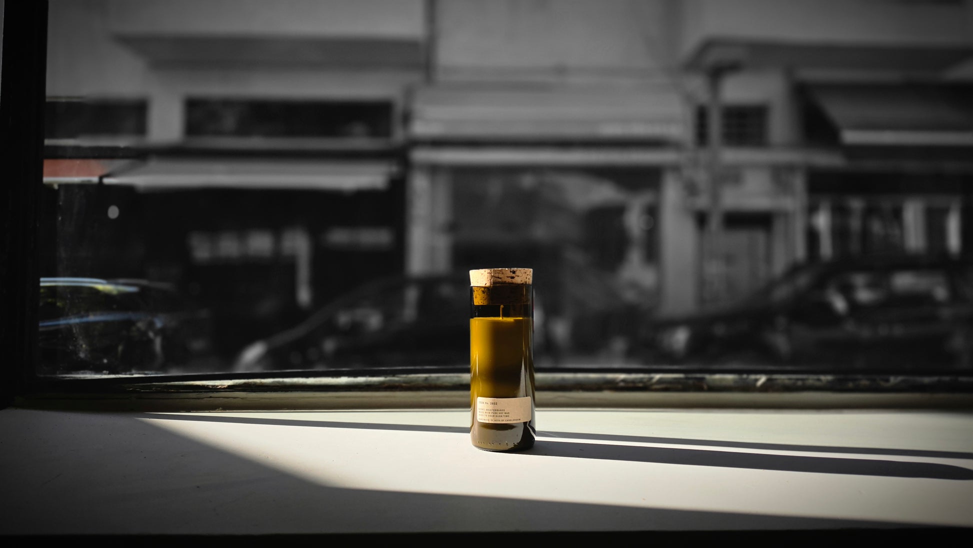Mediterraneo Loft Botanical Candle with cork stopper in dramatic black and white window light